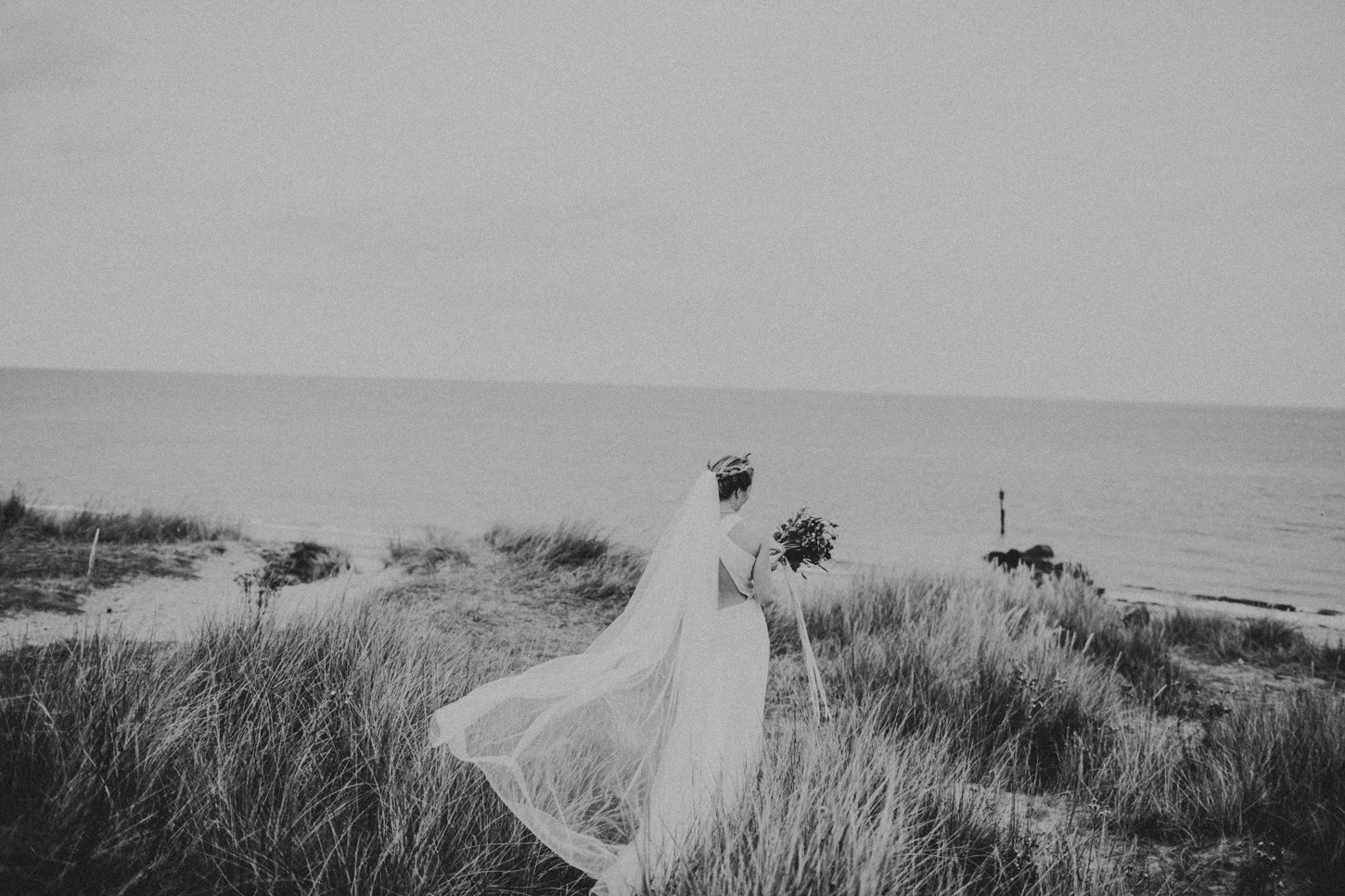 black and white image of bride in dunes 