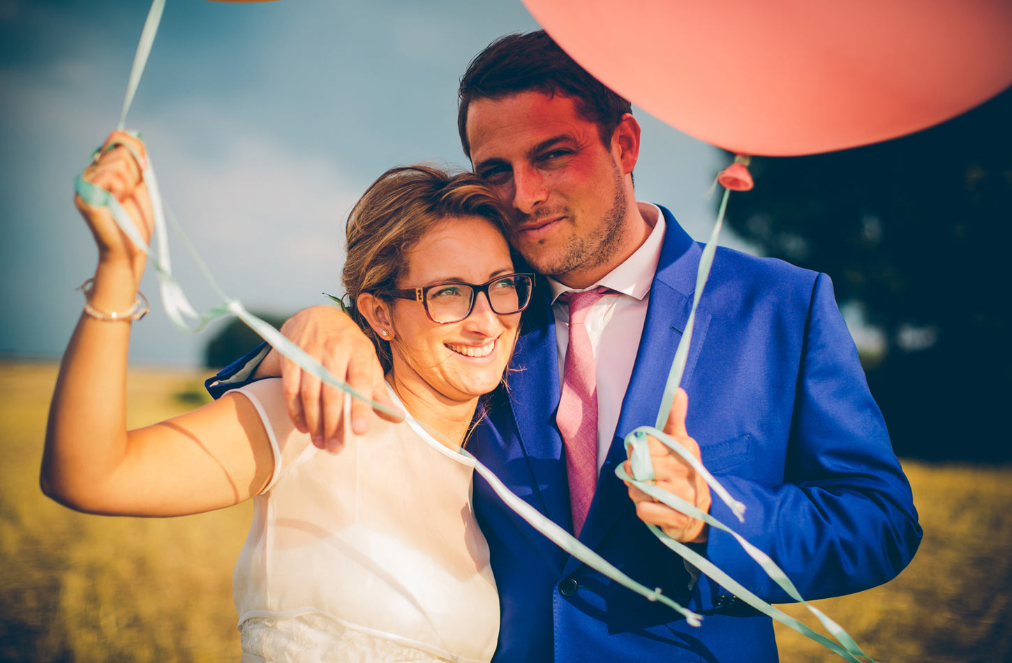 bride and groom in field with balloons by Tori Hancock Photography